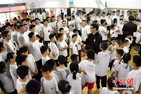  袁师傅的弟子涵盖了各个年龄段，年纪最大的今年65岁，还有很多正在上小学小朋友。还吸引了不少外国人学习咏春。图为袁师傅和弟子在拳馆。受访者供图