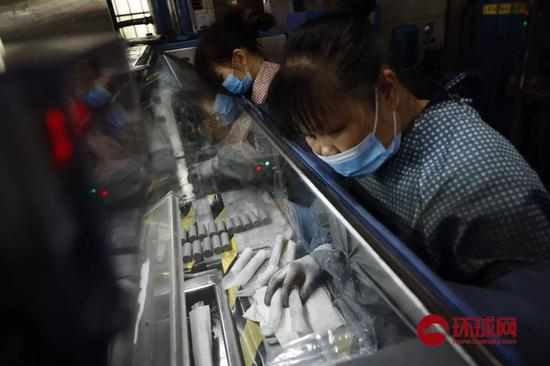  工人将成型的稀土粉末码盒（资料图来源：环球网）