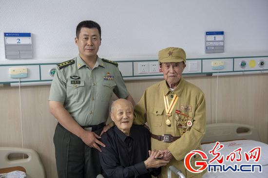 刘聪普远赴来凤县探望张富清，两人的手紧紧相握。（资料图）