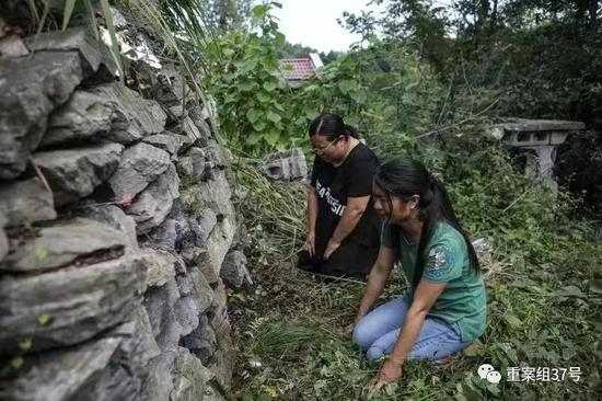 　　▲2019年8月15日，湖南慈利县洞溪村，两姐妹来到父亲坟前祭拜，而旁边的房屋就是杀人凶手的家。新京报记者 彭子洋 摄