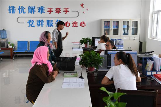 　　在武威市古浪县黄花滩生态移民区富民新村党群服务中心便民大厅，村民前来办理业务（8月22日摄）。新华社记者 范培珅 摄