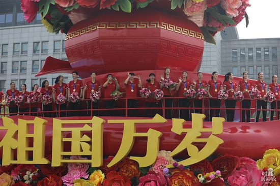 △前一天习近平总书记刚刚亲切会见的中国女排姑娘们就在这辆彩车上。（央视记者魏帮军拍摄）