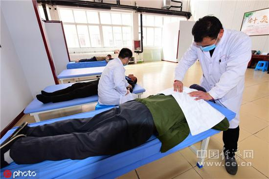 2018年4月10日，山东省潍坊青州市实行“以养融医”模式的安康养老中心的医生为老人们康复按摩。（图片来源：东方IC）