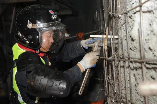  隧道施工人员打风锚杆现场（刘明川&nbsp;摄）