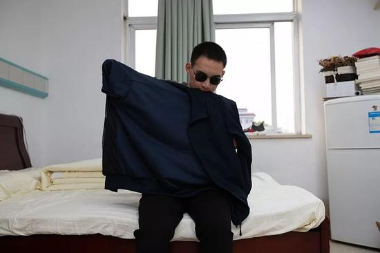 2019年10月24日，重庆西南医院康复楼，清晨，杜富国洗漱完毕后独自穿衣服。新京报记者 李凯祥 摄