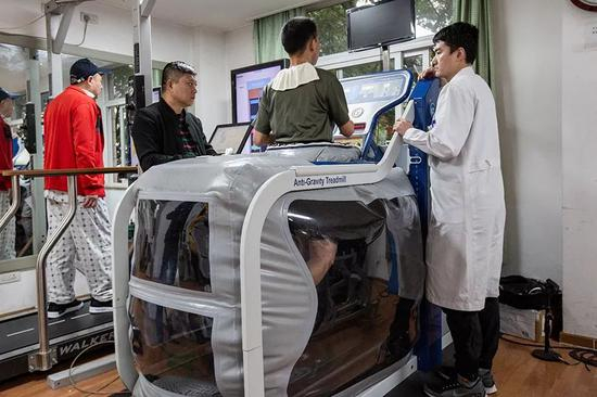 2019年10月24日，杜富国在技师唐鹏的指导下接受反重力跑台训练。新京报记者 李凯祥 摄