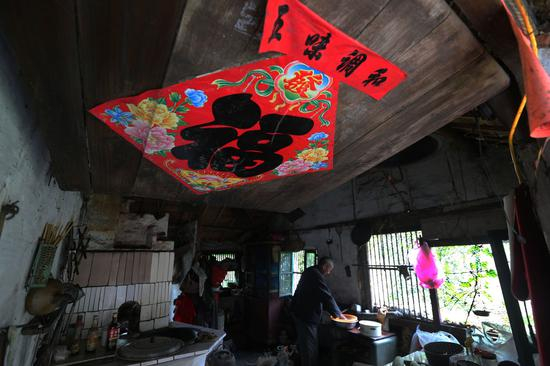 吴锦泉老人在自家厨房忙碌（新华社）