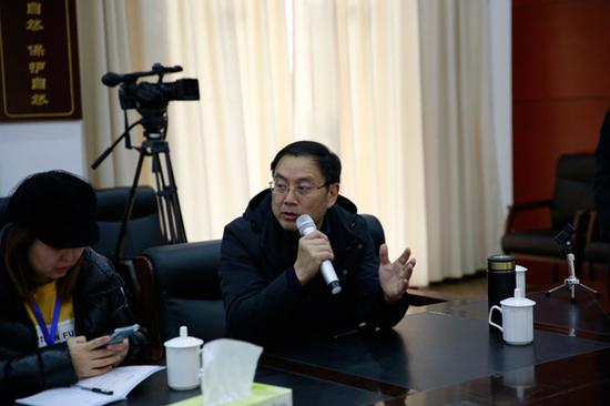 胡文向记者介绍专家咨询委员会（光明网记者 赵宇豪/摄）