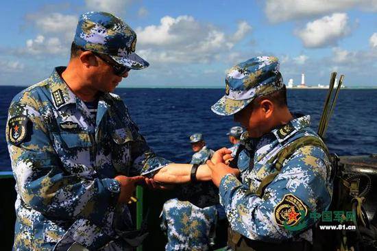 海军战士崇拜地抚看杨志亮手上留下的战伤。 来源：中国军网