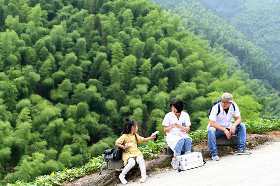  张清语和爸妈在清溪村的路边休息。