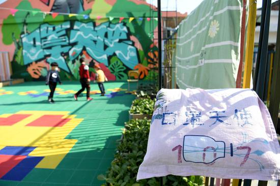 三名小朋友在“中途宿舍”房顶的活动区玩耍。