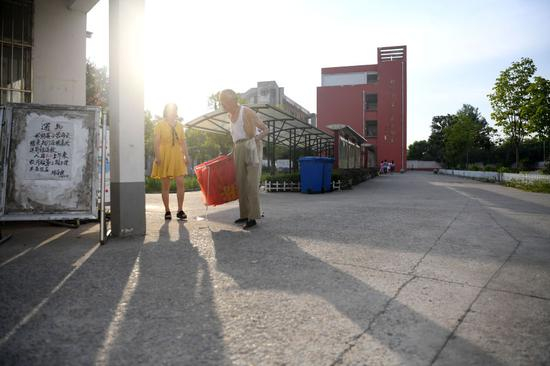 7月31日清晨六点多，叶连平在卜陈学校门口和值班老师交流。