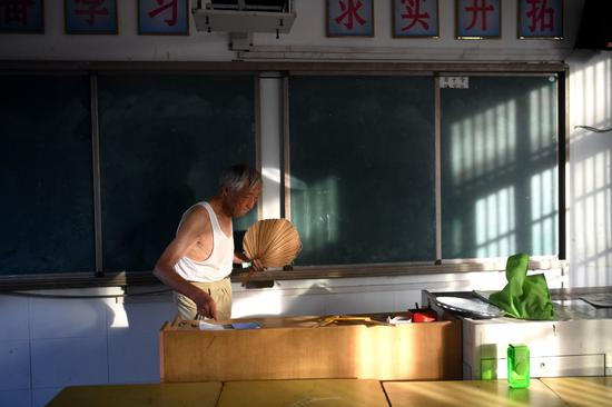 7月31日清晨六点多，叶连平来到卜陈学校暑期补习教室收拾讲台。