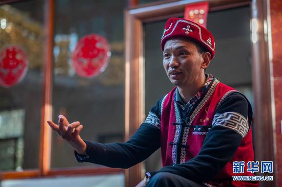 　　在腾冲市清水乡三家村中寨司莫拉佤族村，村民李发顺在介绍他家顺利脱贫的故事（1月19日摄）。 新华社记者 胡超 摄