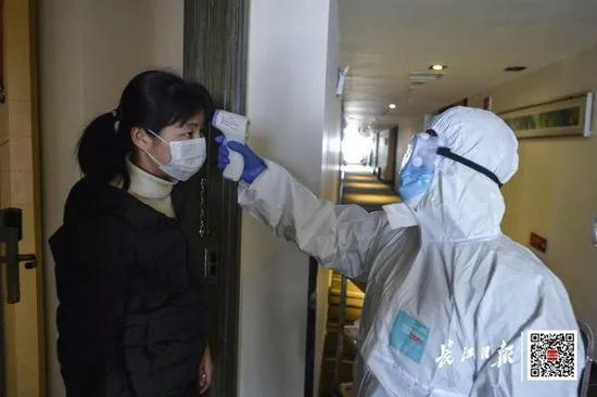  ▲1月30日，武汉市江岸区某医学隔离观察点，医护人员给隔离患者测体温 长江日报记者胡冬冬 摄