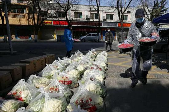 湖北省武汉市下沉花桥社区的干部在搬运居民订购的草莓。新华社记者 沈伯韩 摄