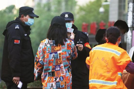 2月14日，江西南昌的一个小区，市民在进入小区时出示自己的身份证。图/中新