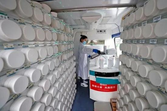 ▲2月26日，在武汉江夏方舱医院院内的“流动应急智能中药房”里，工作人员吴志婷把盛有药方中包含的单味药的药瓶取下来后，逐一扫描确认，准备制药。新华社记者沈伯韩摄