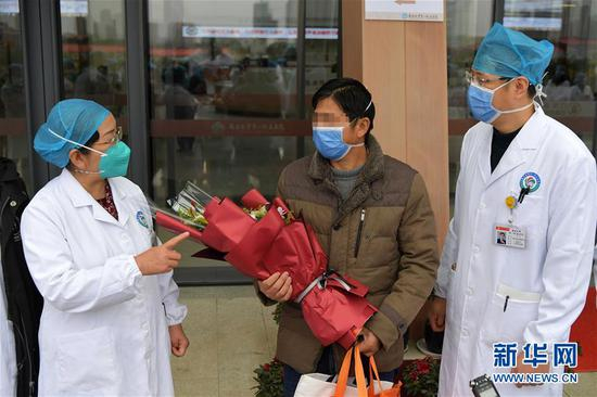  在南昌大学第一附属医院，江西省疫情防控应急指挥部高级别专家组组长、南昌大学第一附属医院院长张伟（左）向出院的患者叮嘱日常注意的事项（1月27日摄）。 新华社记者 彭昭之 摄