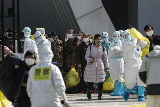 　　3月7日下午，武汉客厅方舱医院外，几名新冠肺炎患者走出医院准备乘车转入雷神山医院。当日上午，武汉客厅方舱医院25人治愈出院，下午59人转到雷神山医院。随着最后一位患者转出，武汉客厅方舱医院患者“清零”。中青报·中青网记者 赵迪/摄