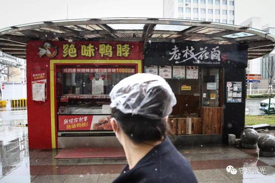 2月15日，湖北省武汉市，一名行人望向两家没有营业的商店。中青报·中青网记者&nbsp;赵迪/摄