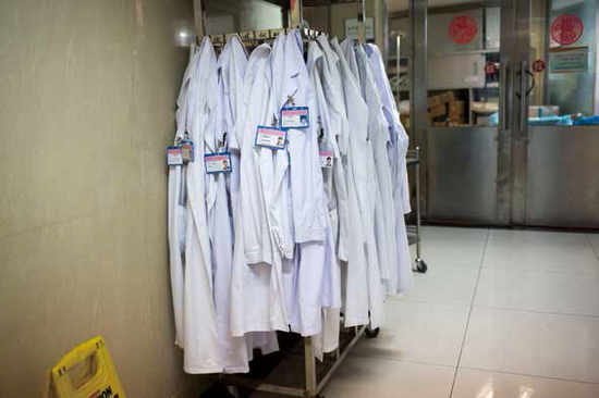 2020年3月20日，广州，呼研院一处挂满白大褂的衣架。图/禤灿雄