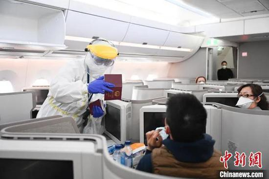  资料图：边检民警登机为旅客进行人证对照　王熙熙　摄