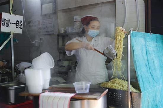 4月22日，在武汉市粮道街的家阳“赵师傅”天天红油热干面店，厨师制作热干面。新华社记者 沈伯韩 摄