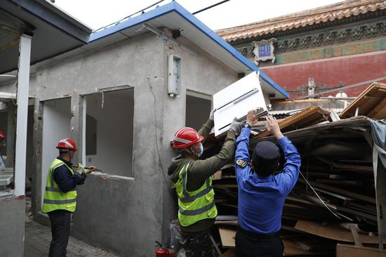 城管执法队队员与工人一起清理建筑垃圾。摄影/新京报记者 侯少卿