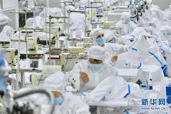  在福建晋江，工人在生产防护服（2月4日摄）。 新华社记者 姜克红 摄