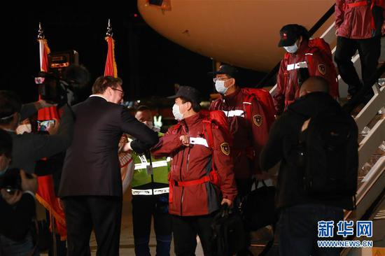 3月21日，在塞尔维亚首都贝尔格莱德，前来迎接的塞尔维亚总统武契奇（左）与中国援助塞尔维亚抗疫医疗专家组成员“碰肘”致意。中国援助塞尔维亚抗疫医疗专家组一行6人21日晚乘专机抵达贝尔格莱德。 新华社记者 石中玉 摄