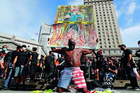  5月29日，纽约上千民众聚集在曼哈顿佛利广场，抗议明尼苏达州明尼阿波利斯市非裔男子乔治·弗洛伊德遭警察暴力执法致死。一名男子利用画作抗议。摄影/ 本刊记者 廖攀
