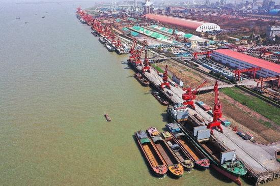 图为2020年3月19日，马钢出口的钢材正在马鞍山港外轮吊装等待外运。陈亚东摄（人民视觉）