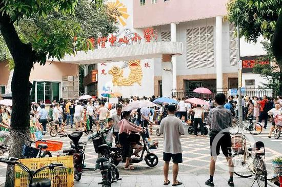  9月21日，广州番禺钟村中心小学，不少家长聚集在校门口接孩子放学。/记者 王敏