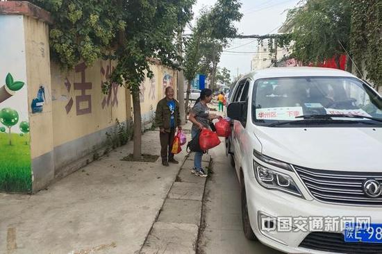 陕西省渭南市华州区大明镇下李村村民拎着采购的货物上客车。高波 摄