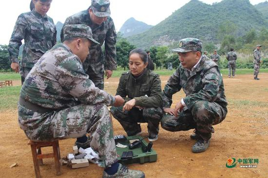 赵丽参加军事日活动，练习枪械分解结合。图片来源：中国军网
