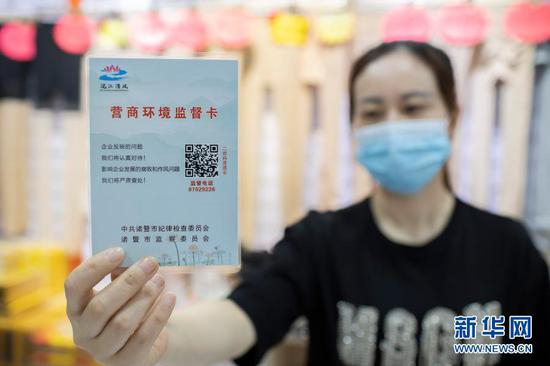  5月12日，浙江诸暨市一经营户在展示“营商环境监督卡”。诸暨市推出“营商环境监督卡”，助力复工复产，服务保障经济稳健发展。新华社发（郭斌 摄）