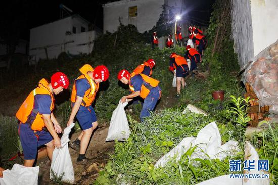　　驰援安徽省阜南县抗洪的洛阳消防支队抗洪抢险突击队队员在郜台乡毕台村保庄圩搬运物资封堵管涌（2020年7月20日摄）。新华社发（郭抗抗 摄）