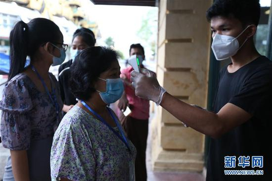 当地时间2020年11月8日，人们在缅甸仰光的一个投票站前排队检测体温。 缅甸当日举行联邦议会选举，产生的新一届联邦议会将选出新一任总统。 新华网 图