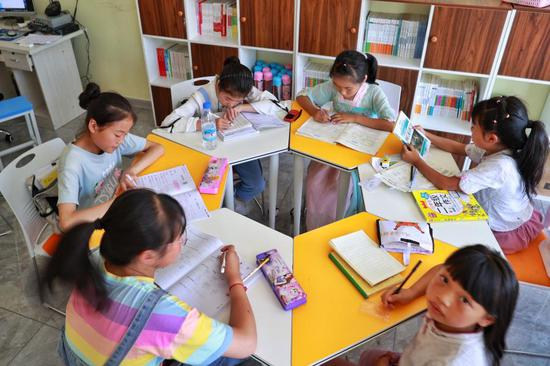 小朋友在毕节市七星关区柏杨林易地扶贫搬迁安置点长幼日间托养照料中心内学习。（新华社记者刘续 2020年8月3日 摄）