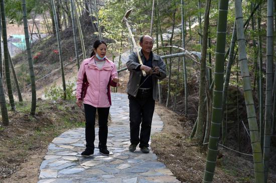 在安徽省金寨县大湾村，大湾村党总支第一书记、驻村扶贫工作队队长余静（左）和村民交流（2020年3月19日摄）。大湾村曾是金寨县71个重点贫困村之一，在余静和村民们的努力下，该村在2018年成功实现脱贫出列。新华社记者 周牧 摄