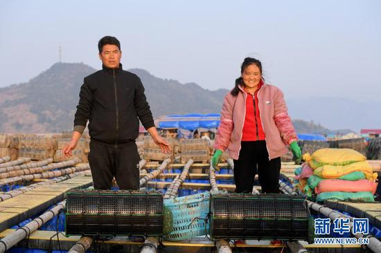 “春运母亲”巴木玉布木与丈夫巫其石且从四川凉山彝族自治州老家辗转来到福建省霞浦县溪南镇海域，从事海上渔排海参养殖。这是2月4日在渔排上拍摄的巴木玉布木（右）与丈夫巫其石且。新华社记者 姜克红 摄