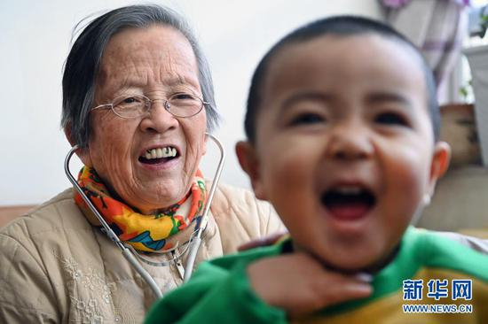 路生梅在佳县家里为患儿义诊（1月16日摄）。新华社记者 陶明 摄