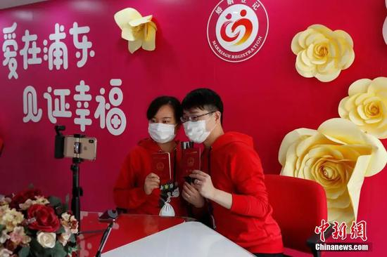  两位市民手持结婚证合影留念。殷立勤 摄