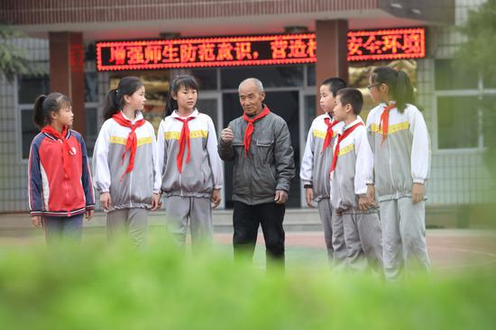 图为闫青海（中）给孩子们讲述西柏坡红色故事&nbsp; 2019年4月8日 梁子栋摄