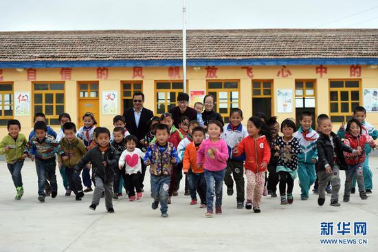 在甘肃省永靖县小岭乡土门村土门小学，校长鲜虎（中）带领全校师生合影（2018年4月26日摄）。在地处甘肃省永靖县城以西约50公里的干旱贫困山区，1989年出生的鲜虎和妻子蒲颜梅克服困难、忍受寂寞、坚守在教育教学第一线，为山区教育事业发展奉献青春年华。新华社记者 范培珅 摄