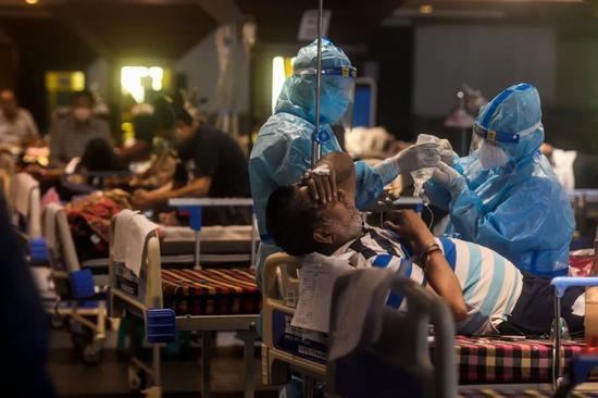 新德里一家新冠肺炎临时救助点，医护人员正在对患者进行救治。来源：纽约时报