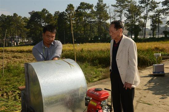 2018年，袁隆平现场指导杂交水稻测产。（左为李建武）&nbsp;&nbsp; 图片由受访者提供