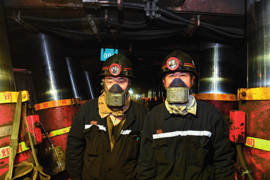 5月25日，内蒙古鄂尔多斯市准格尔旗麻地梁煤矿采煤区电工黄照希（左）和电工施君天在井下&nbsp;贝赫摄