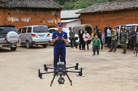 ▲6月5日，云南省森林消防总队无人机侦察小组利用无人机监测象群方位，吸引村民围观。新京报记者 郑新洽 摄